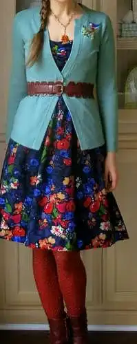 Floral dress under a turquoise cardigan with brown belt at waist